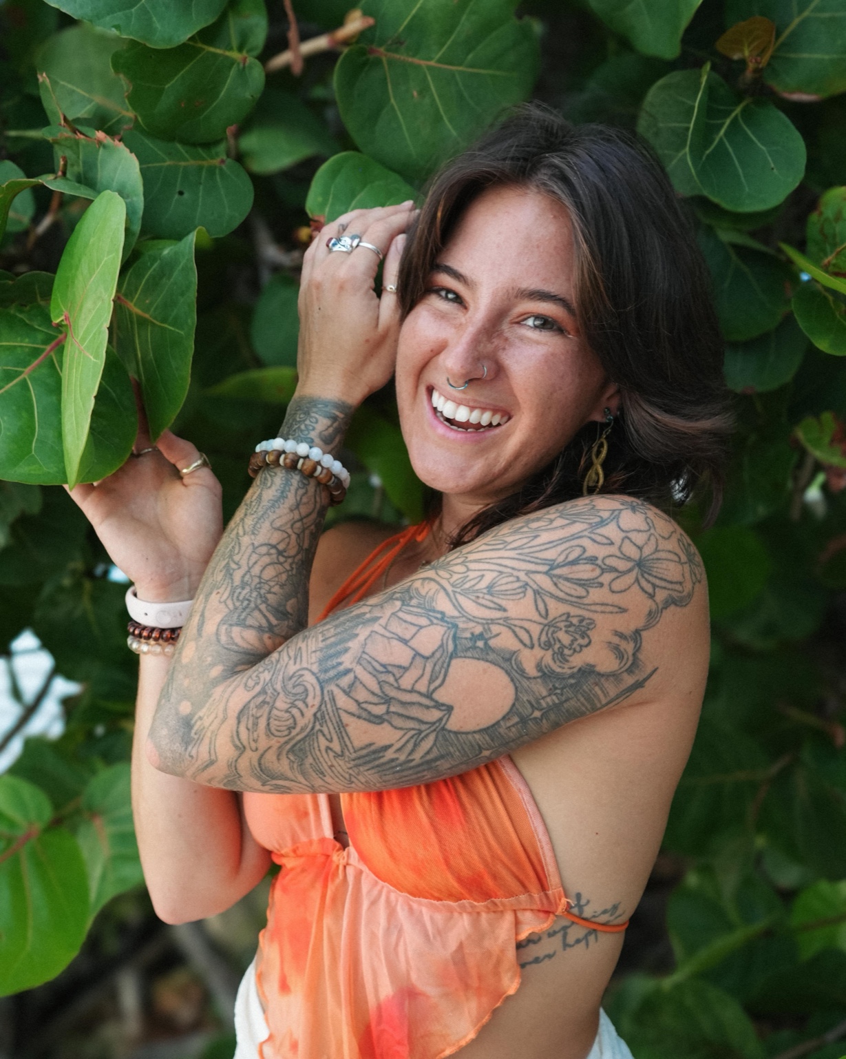 Megan Nardi smiling, outdoors among green leaves.